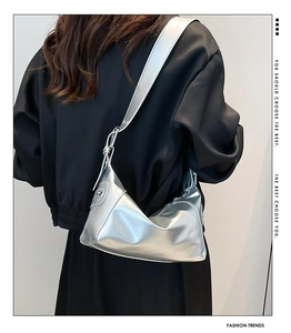 Detalle de bolso plateado metalizado en cuero PU brillante con correa ancha ajustable