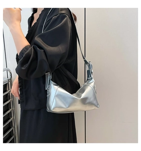 Detail showing the adjustable wide strap and metallic buckle on silver hobo bag