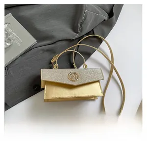 Macro view of light gold crossbody bag with metallic M logo and sequined leather texture