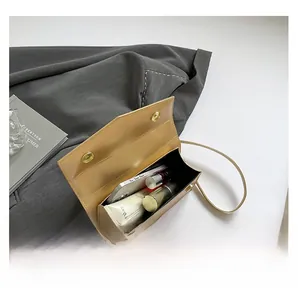 Detail showing the internal storage capacity of the yellow leather crossbody square bag