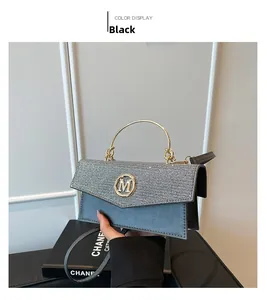 Detail of grey crossbody bag featuring sequin flap, gold M logo and curved metal handle