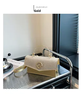 Detailed close-up of champagne gold sequin handbag with U-shaped metal handle and M logo