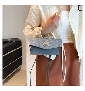 Detail of square crossbody bag featuring silver rhinestones and golden M metal logo