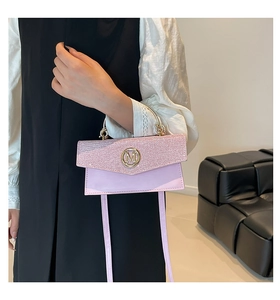 Detail of pink sequin bag with golden M buckle and metallic handle on model