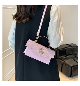 Detailed back view of model wearing a pink glitter handbag with gold M logo and leather strap