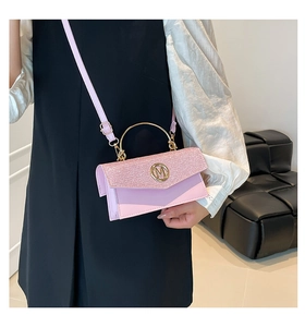Detailed close-up of pink glitter rectangular handbag with golden M logo and metal handle