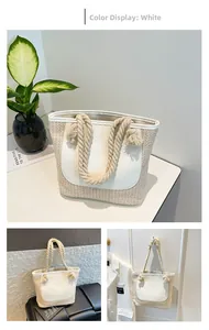 Detail of woven straw tote bag with thick rope handles and white leather trim