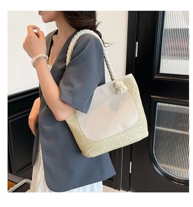 Detail of summer straw tote bag with faux leather patch and cotton rope handle