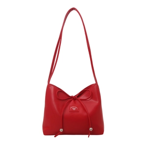 Vibrant red minimalist shoulder bag with slender bow and metallic beads on white background