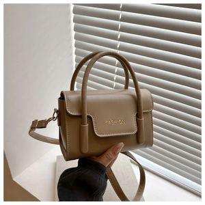 Details der khakifarbenen Lederhandtasche mit goldenem Fashion-Text und Zierstreifen