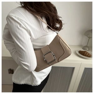 Sac porté épaule beige avec boucle argentée porté par un mannequin dans un cadre épuré