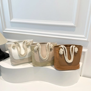Minimalist straw woven tote bags in white and brown with leather trim and rope handles
