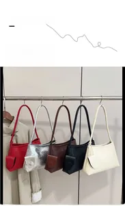 Detail view of woven leather underarm bags in five colors with round pouch charms