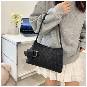 Detail of black woven underarm bag with unique leather sunglasses holder accessory
