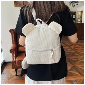 Nahaufnahme des weißen Cord-Rucksacks mit 3D-Bärenohren und gewebter Quaste am Reißverschluss