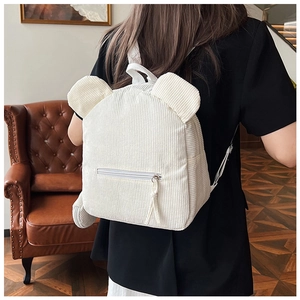 Nahaufnahme eines weißen Mini-Rucksacks aus Cord mit Bärenohren, von einem Model getragen