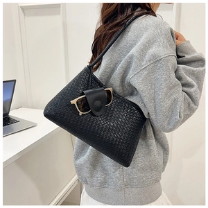 Detailed texture of black woven tote bag with functional leather glasses holder strap