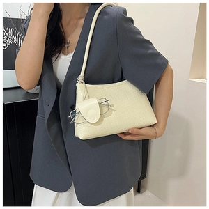 Detail of cream woven shoulder bag featuring a matching hanging eyewear pouch accessory