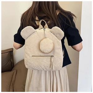 Detail eines beigen Cord-Rucksacks mit niedlichen Bärenohren und passender Geldbörse
