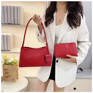 Detail view of woven leather texture on red tote bag with a matching small pouch