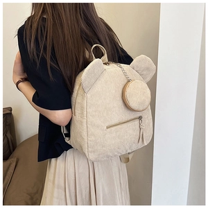 Detail of beige corduroy backpack with cute bear ears and circular coin purse attachment