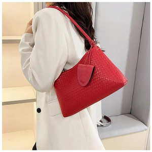 Detail of red woven leather tote bag showing intricate texture and luxury finish