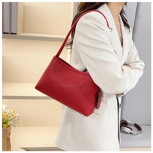 Detail of red woven texture shoulder bag worn with white blazer for a stylish look