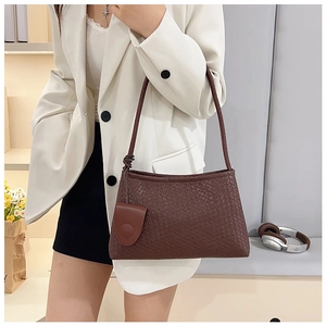 Deep coffee woven shoulder bag shown as a crossbody style on a female model