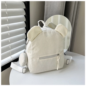 Detail eines cremefarbenen Cord-Rucksacks mit Bärenohren und kleinem runden Münzfach