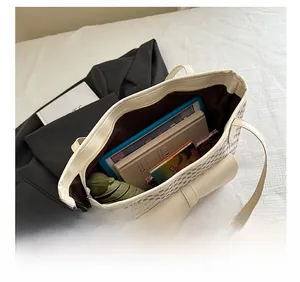 Top view of the interior space of a large capacity tote bag holding books and an umbrella