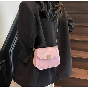 Detailed view of pink patent leather square bag with gold heart clasp and chain strap