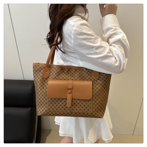 Close-up of a large tote bag featuring brown geometric prints and a leather front pocket