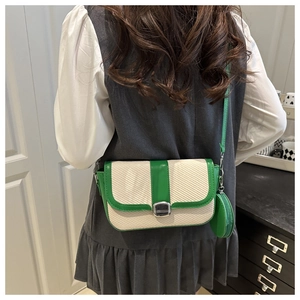 Detail of cream woven crossbody bag with green leather trim and mini coin purse