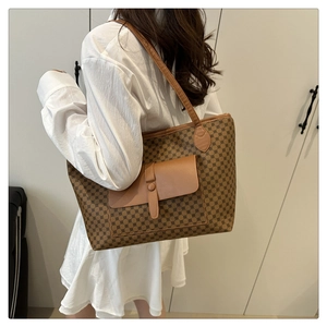 Brown monogram tote bag with front flap pocket and spacious interior on a model