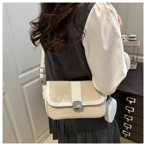 Detail of woven saddle bag with leather trim and mini round pouch on shoulder strap
