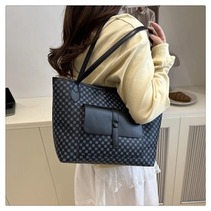 Detail of large tote bag with geometric star pattern and black flap pocket shown on model