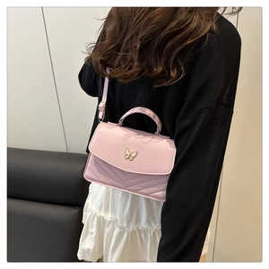 Pink quilted crossbody bag featuring a golden butterfly clasp and adjustable strap