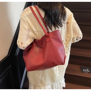 Red woven texture tote bag showcased on a shoulder in a stylish urban setting