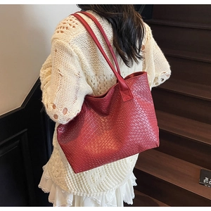 Close-up of red woven texture on a large capacity tote bag with long shoulder straps