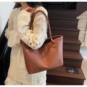 Detail shot of a dark brown large tote bag with woven leather texture for daily commute