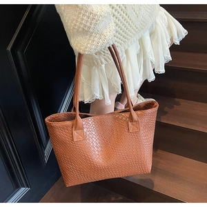 Detail shot of the woven brown leather texture on a large capacity vintage tote bag