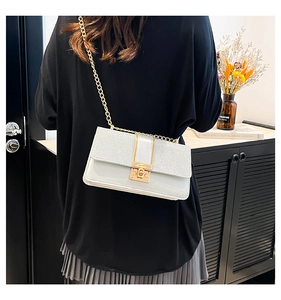 Lifestyle shot showing a silver sequined crossbody bag with a gold chain and metal clasp