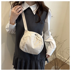 Minimalistische beige Cord-Umhängetasche mit Doppelreißverschluss am Modell