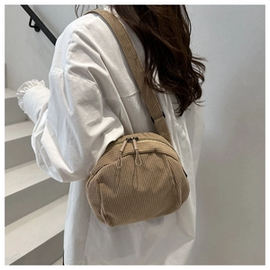 Braune Cord-Umhängetasche an einem Modell mit Doppelreißverschluss und minimalistischem Stil