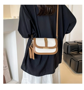 Detalle del bolso de silla retro con bloques de color y hebilla dorada en una modelo
