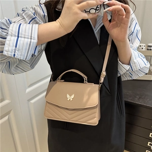 Chic beige quilted crossbody bag with butterfly buckle and V-shaped stitching detail