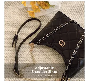 Detail view of the black quilted shoulder bag with adjustable chain strap and gold hardware