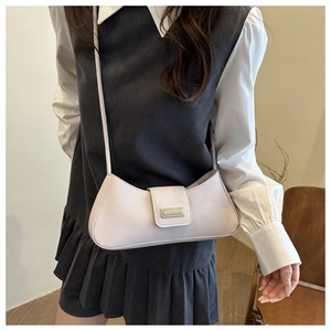 Detail of minimalist cream PU leather underarm bag with metal buckle on grey vest dress