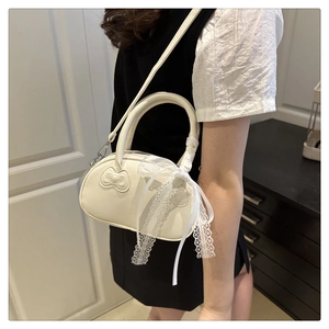 Detail of white PU leather bowling bag with lace bow handle and embossed bow pattern