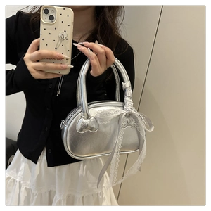 Silver metallic pillow handbag featuring white lace ribbon and 3D bow detail